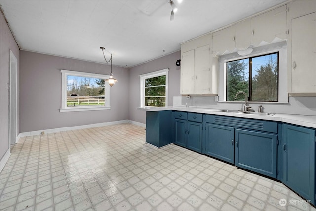 kitchen with decorative light fixtures, blue cabinets, and sink