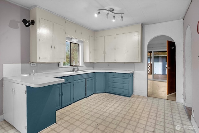 kitchen featuring sink, white cabinetry, and blue cabinets