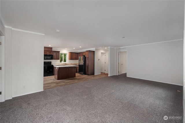 unfurnished living room with crown molding and dark colored carpet