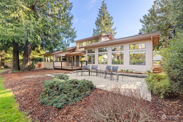 back of house featuring a deck and a patio area