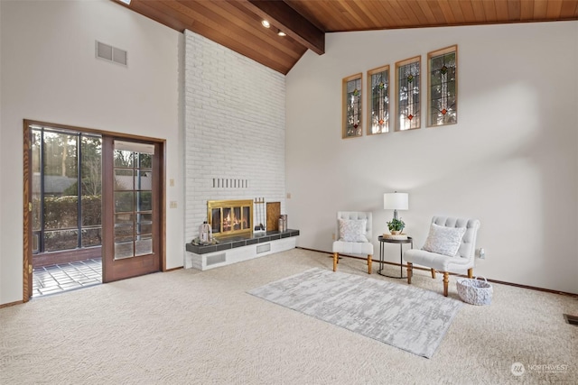 sitting room with carpet floors, a brick fireplace, beamed ceiling, high vaulted ceiling, and wooden ceiling