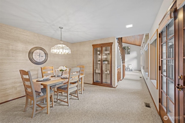 dining room with light carpet and a notable chandelier