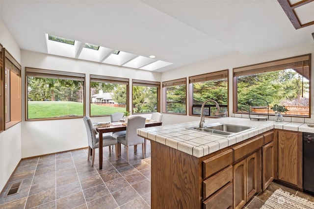 sunroom / solarium with a wealth of natural light, a skylight, and sink