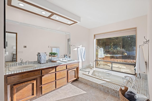 bathroom with vanity, tile patterned floors, and tiled tub