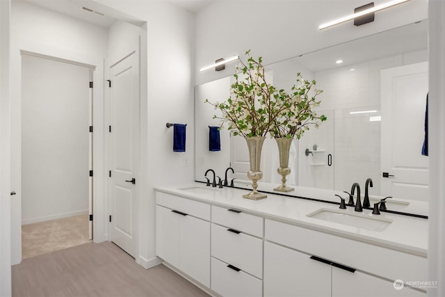 bathroom featuring vanity, hardwood / wood-style flooring, and a shower with door