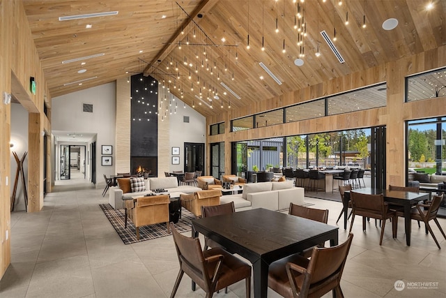 dining space with high vaulted ceiling, a large fireplace, beamed ceiling, and wooden ceiling