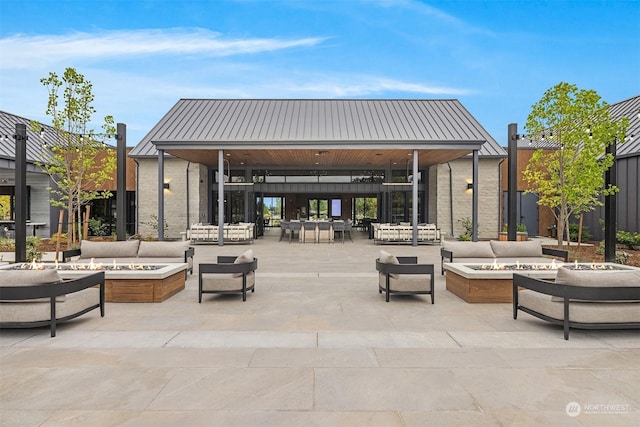 view of patio featuring a gazebo and an outdoor living space with a fire pit