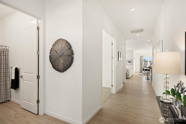 hallway featuring light wood-style flooring, visible vents, baseboards, and recessed lighting