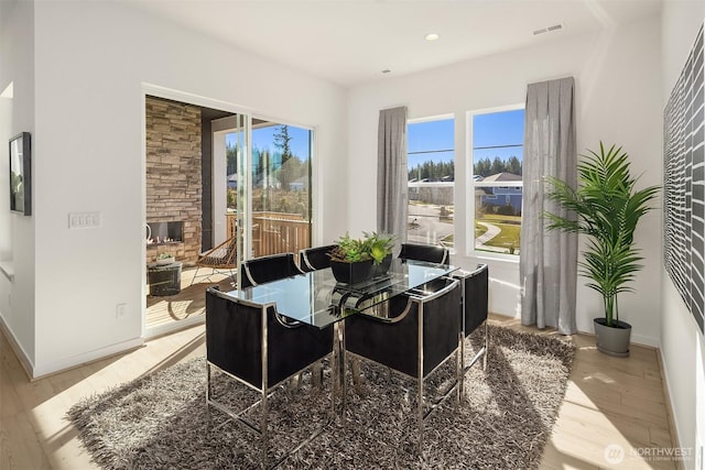 dining space featuring a wealth of natural light, visible vents, baseboards, and wood finished floors