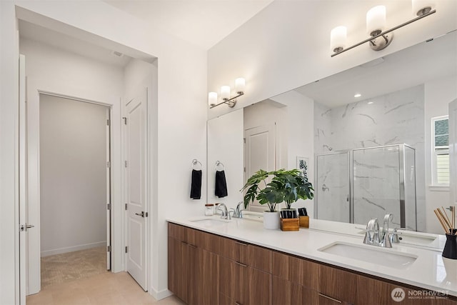 full bathroom featuring double vanity, a marble finish shower, and a sink