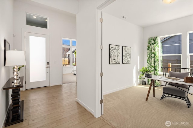 office featuring light wood-style floors, visible vents, and baseboards