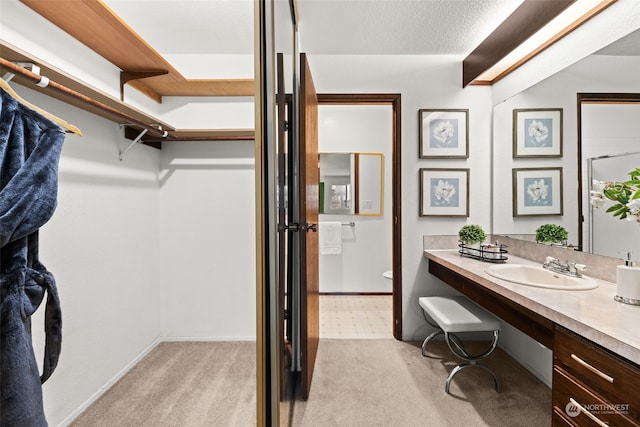 bathroom with toilet, a textured ceiling, and vanity