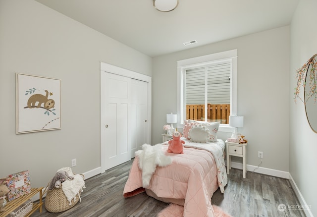 bedroom with dark wood-type flooring and a closet