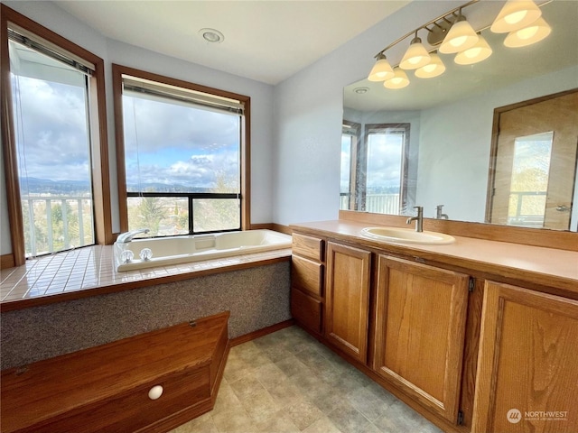 bathroom with tiled bath and vanity