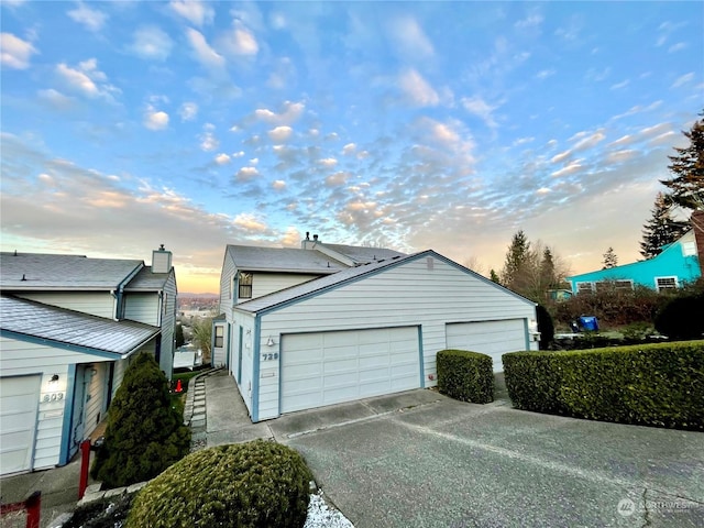 property exterior at dusk featuring a garage