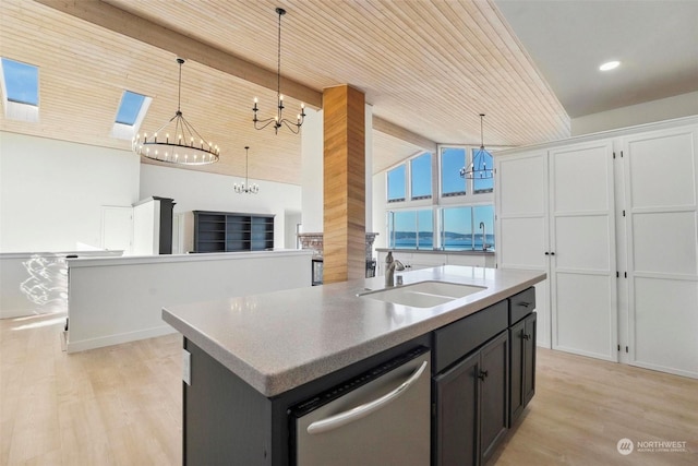 kitchen with dishwasher, sink, an island with sink, and a chandelier