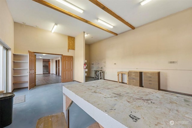 kitchen with beam ceiling and a high ceiling