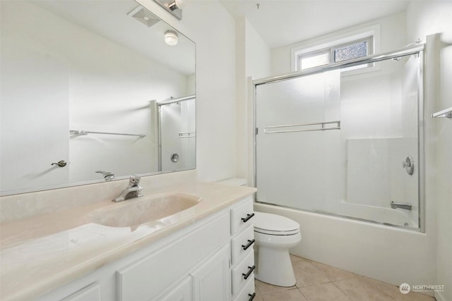 full bathroom featuring toilet, vanity, combined bath / shower with glass door, and tile patterned flooring