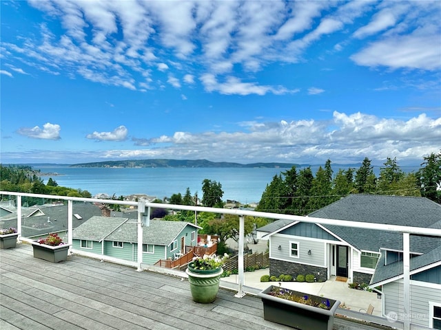 wooden deck with a water and mountain view