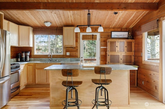 kitchen featuring pendant lighting, sink, plenty of natural light, a kitchen island, and rustic walls