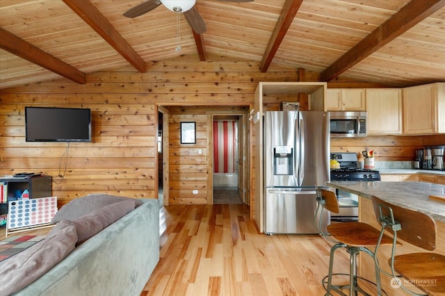 kitchen featuring light hardwood / wood-style floors, lofted ceiling with beams, stainless steel appliances, and wooden walls