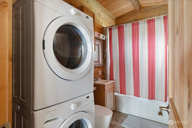 clothes washing area with tile patterned flooring, sink, wooden ceiling, stacked washer and dryer, and wooden walls
