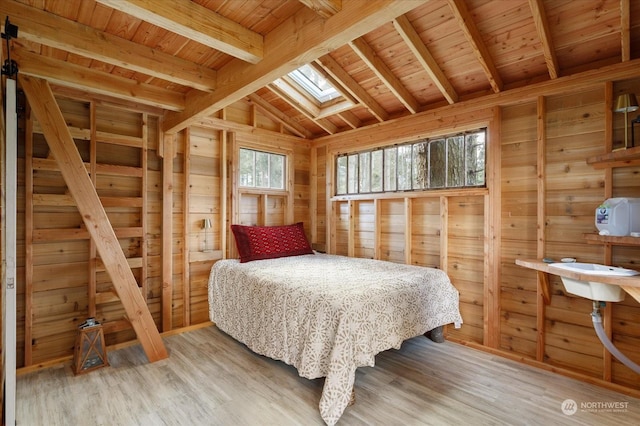 bedroom featuring vaulted ceiling with skylight, hardwood / wood-style floors, wooden ceiling, and multiple windows