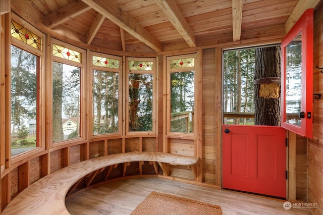 unfurnished sunroom with wood ceiling, a healthy amount of sunlight, and lofted ceiling with beams