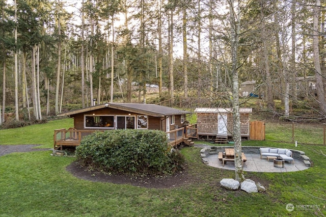 view of yard featuring a patio area, a wooden deck, and an outdoor living space with a fire pit