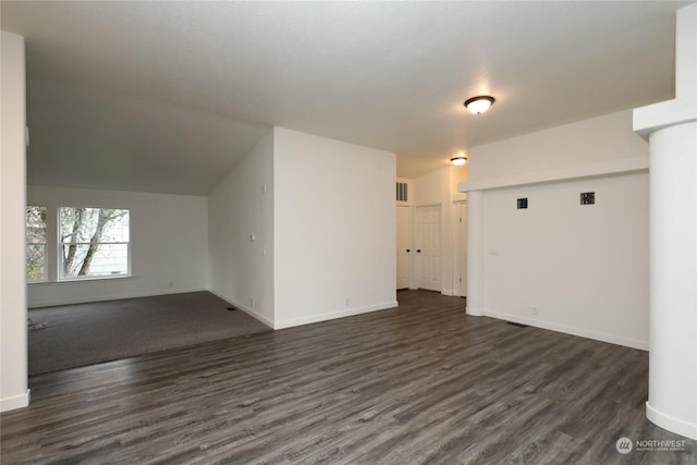 interior space with vaulted ceiling and dark hardwood / wood-style flooring