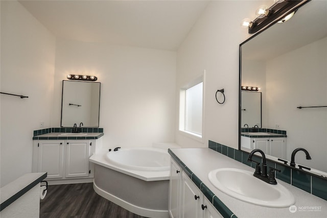 bathroom featuring a bath, hardwood / wood-style flooring, and vanity