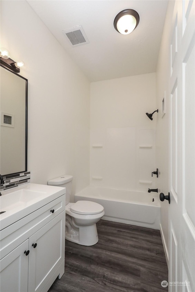 full bathroom with hardwood / wood-style flooring, bathtub / shower combination, toilet, and vanity