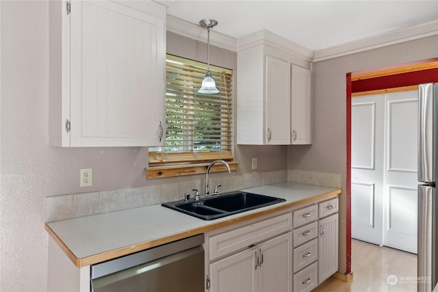 kitchen featuring sink, crown molding, hanging light fixtures, dishwasher, and white cabinets