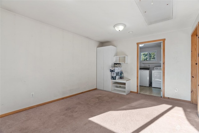 carpeted spare room featuring independent washer and dryer