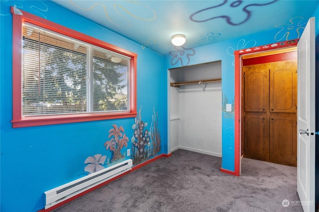 unfurnished bedroom featuring carpet floors, a closet, and a baseboard heating unit