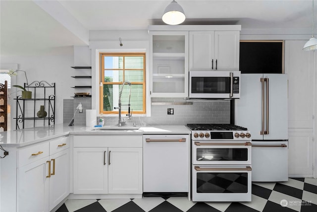 kitchen with pendant lighting, white appliances, white cabinets, sink, and kitchen peninsula