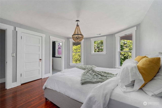 bedroom featuring dark hardwood / wood-style flooring and a chandelier