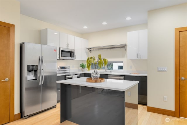 kitchen featuring light hardwood / wood-style floors, white cabinetry, a center island, and stainless steel appliances