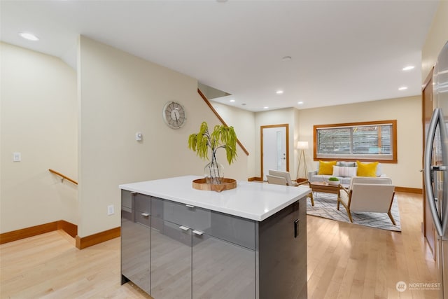 kitchen with stainless steel fridge, light hardwood / wood-style flooring, and a kitchen island