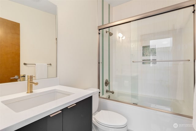 full bathroom with toilet, enclosed tub / shower combo, and vanity