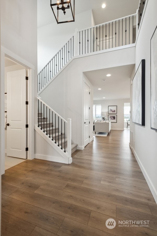 foyer entrance featuring a high ceiling, an inviting chandelier, and hardwood / wood-style floors