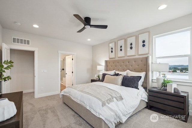 bedroom featuring ceiling fan, ensuite bathroom, and light carpet