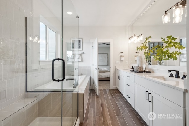 bathroom with a shower with shower door and vanity