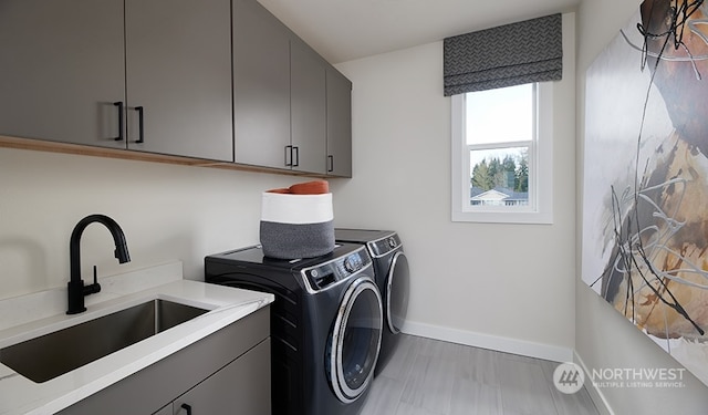 washroom featuring cabinets, sink, and washing machine and clothes dryer