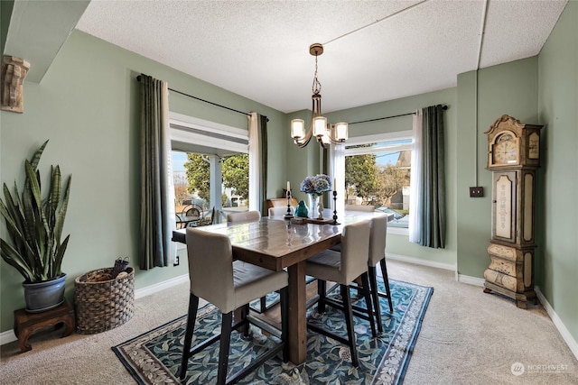 dining area with an inviting chandelier, carpet, and a textured ceiling