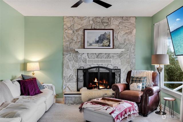 living room featuring ceiling fan and a fireplace