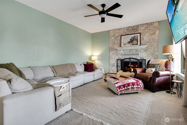 carpeted living room with ceiling fan, a fireplace, and a textured ceiling