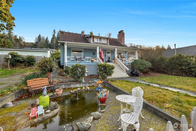 view of front of house featuring covered porch and a front lawn