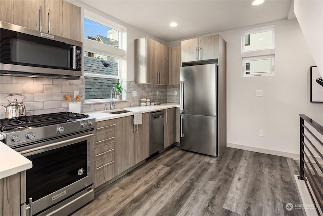 kitchen with tasteful backsplash, dark wood-type flooring, sink, and stainless steel appliances