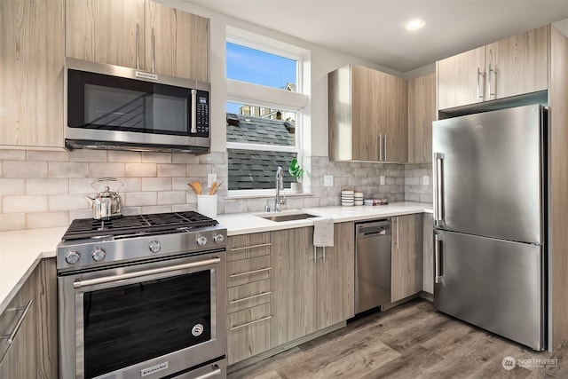 kitchen featuring appliances with stainless steel finishes, dark hardwood / wood-style flooring, backsplash, and sink